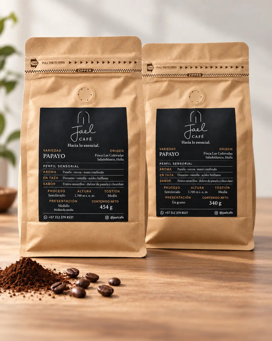 Dos presentaciones de café Papayo JAEL: 454 g molido medio y 340 g en grano, sobre una mesa con café molido y granos